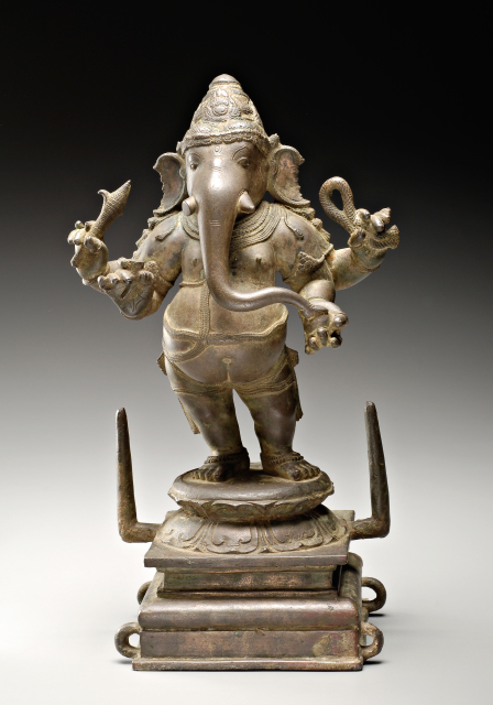 Pot-bellied elephant-headed deity standing on a double lotus supported on plinth. The figure holds a goad, noose, sweetmeat and tusk in his four hands.