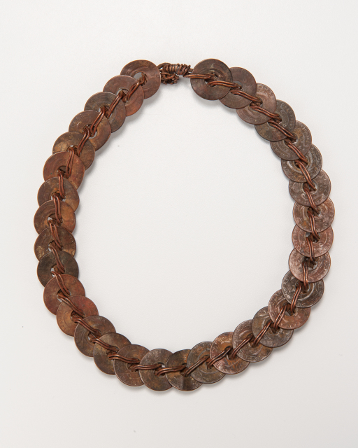 A necklace comprised of a series of flat rings, connected tightly together with copper wire.