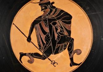 A stemmed cup with two handles and a wide bowl is decorated on the interior with a male figure in a running pose. He is painted entirely in black and is placed in a circle with a reddish background. Both sides of the exterior are decorated with two large eyes and a red-figured woman who holds a dolphin in each hand.